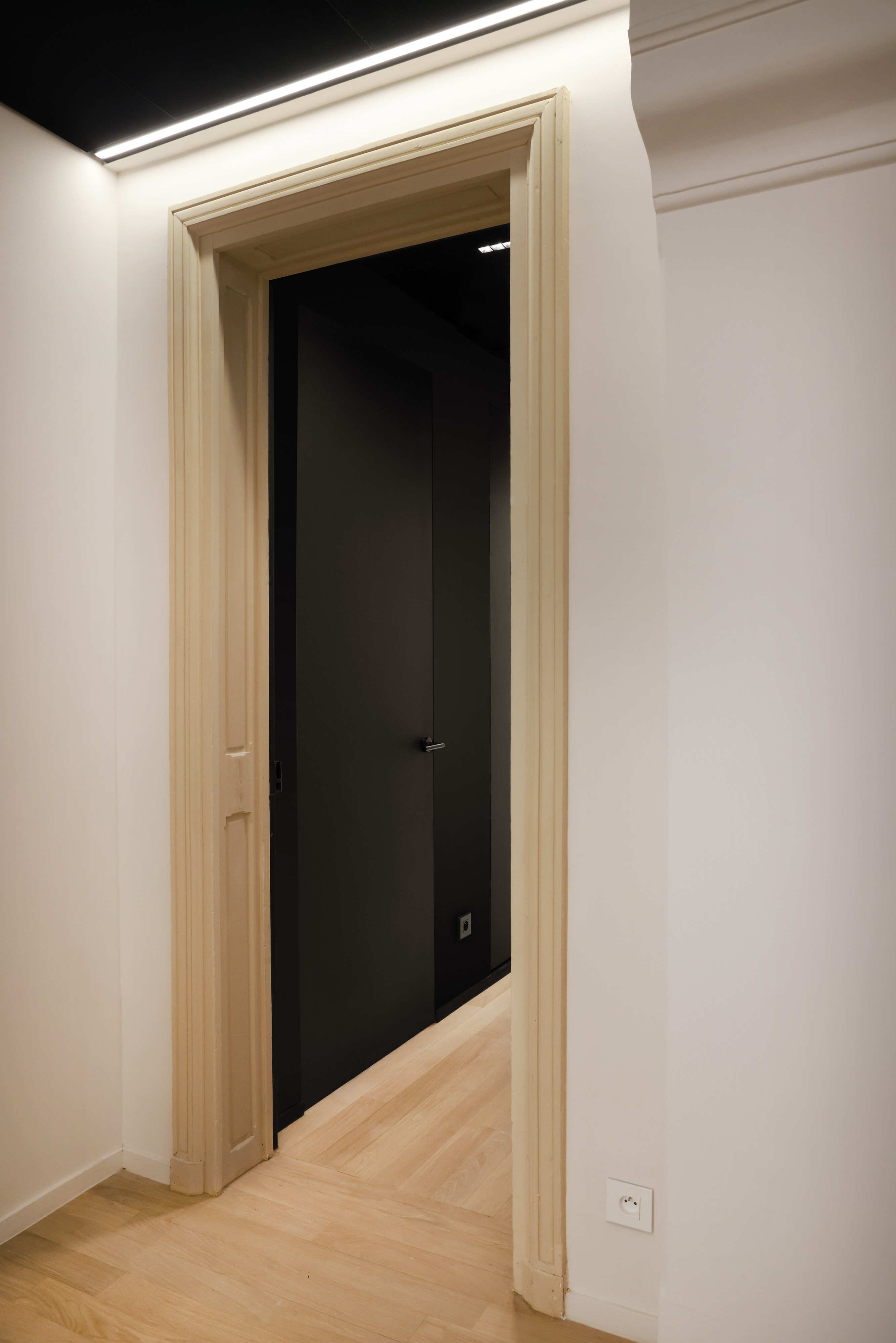 Zwarte deuren geïnstalleerd met onzichtbare deurkaders uit het invisidoor gamma van ARLU. De deur ligt gelijk met de wand en is nagenoeg onzichtbaar.