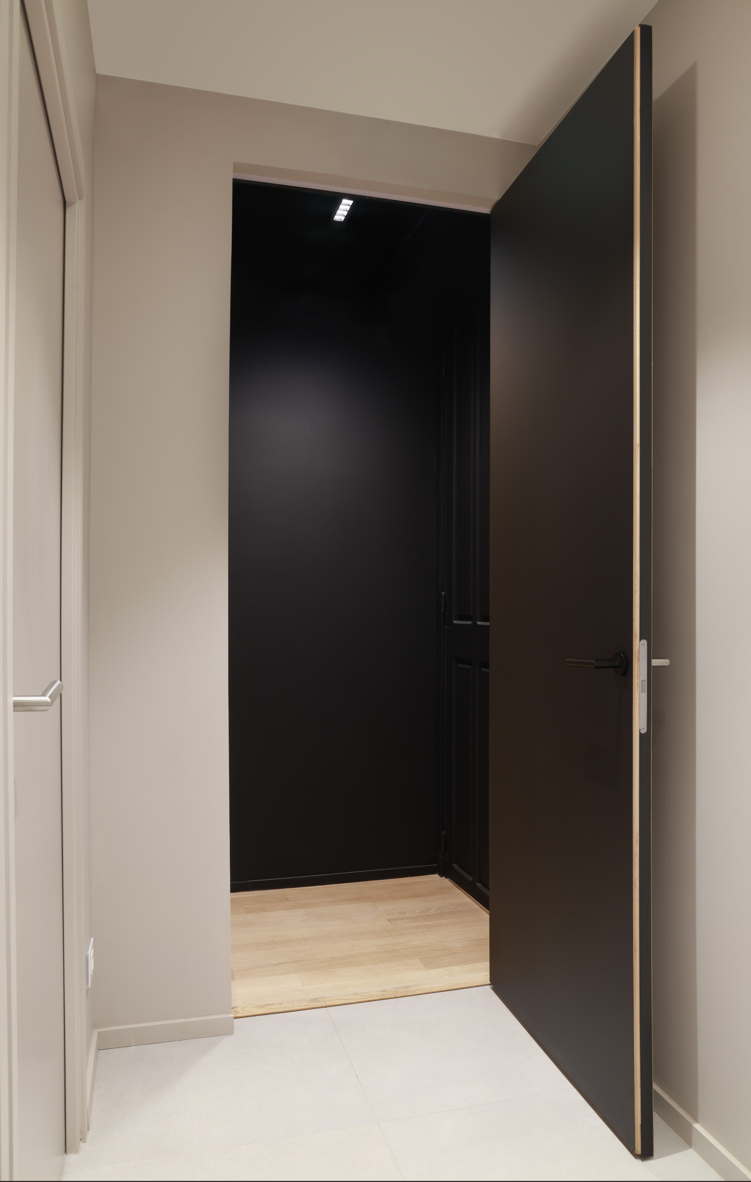 Zwarte deuren geïnstalleerd met onzichtbare deurkaders uit het invisidoor gamma van ARLU. De deur ligt gelijk met de wand en is nagenoeg onzichtbaar.