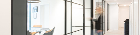 Zwarte glazen scheidingswand gecombineerd met glazen draaideur (product: divina ARLU) geïnstalleerd bij MFI Coatings.