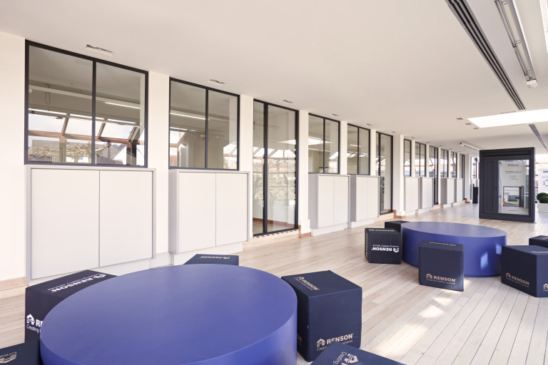 Integratie van divina glazen scheidingswanden (zwarte aluminium) en glazen draaideuren (zwart aluminium) bij Renson Academy. 