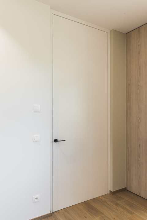 Intégration de charnières invisibles pour les portes en bois au ras du mur.