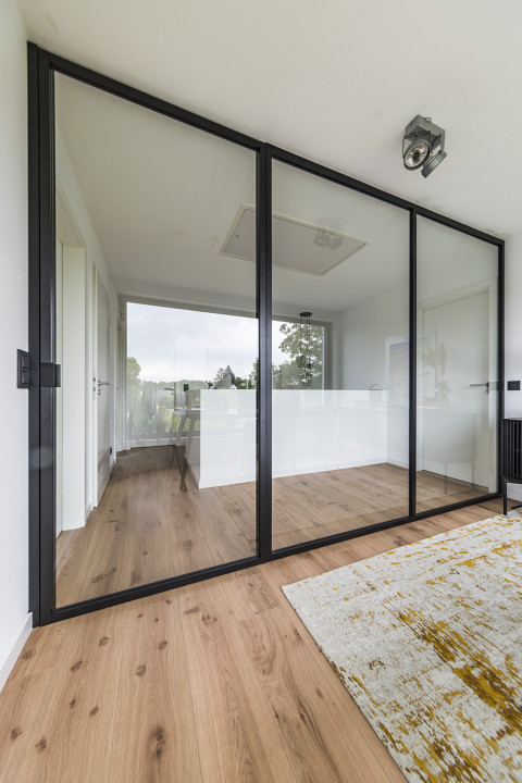 Separation between office and hall without loss of light and openness thanks to ARLU's divina - a glass divider with glass swing door